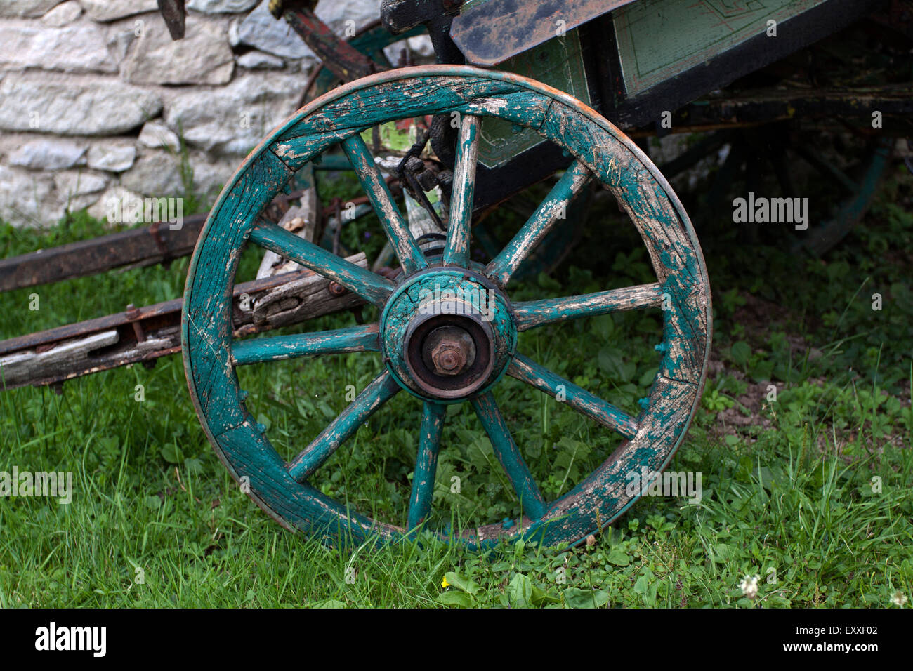 Wooden wheel and hay on meadow. Rural scene Stock Photo