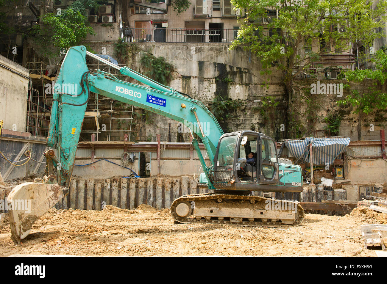 Excavator at a standstill while operator naps, Hong Kong China Stock Photo