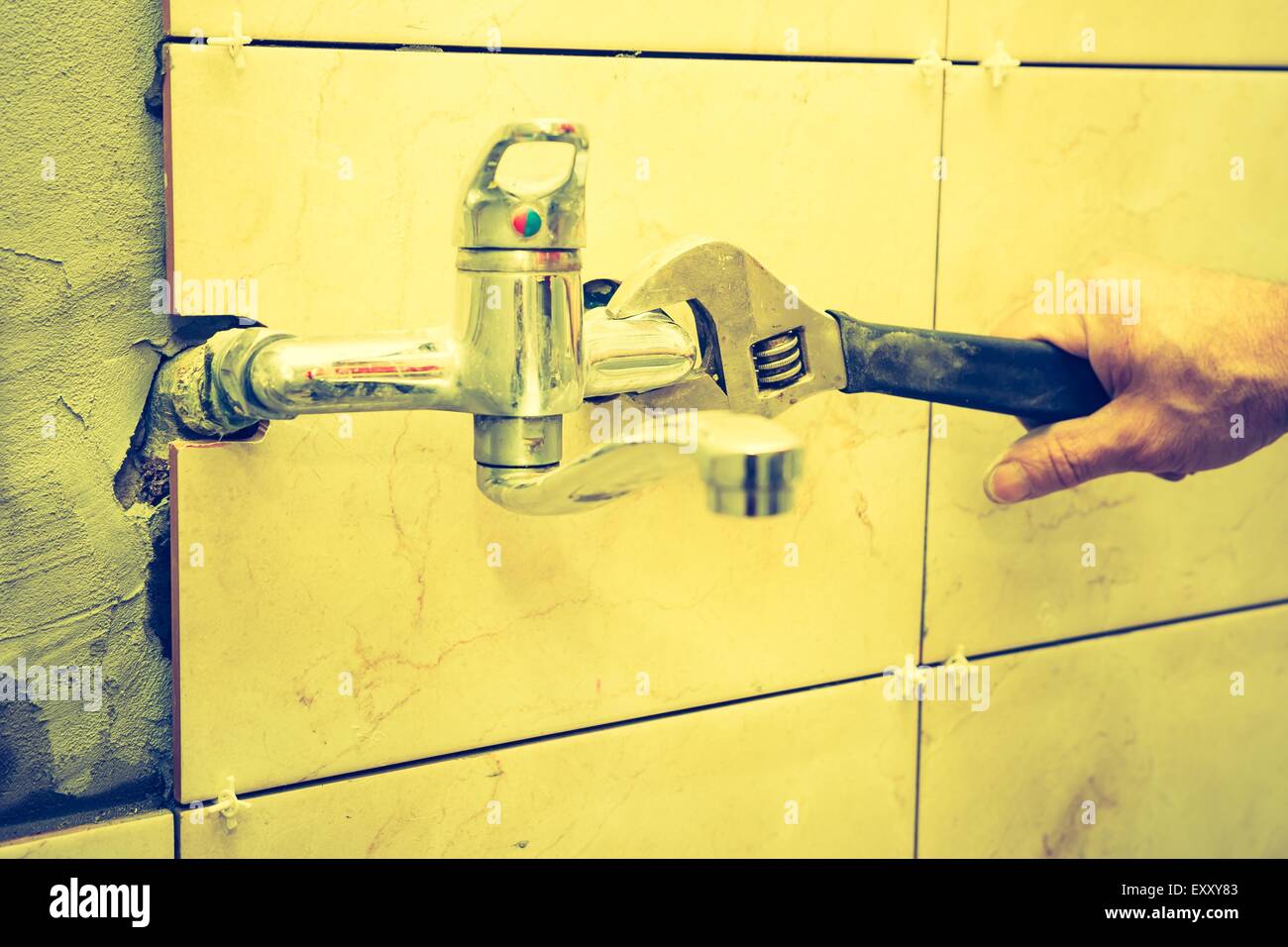 Vintage photo of plumbers hands tightening a water pipe. Authentic and accurate content depiction. Stock Photo