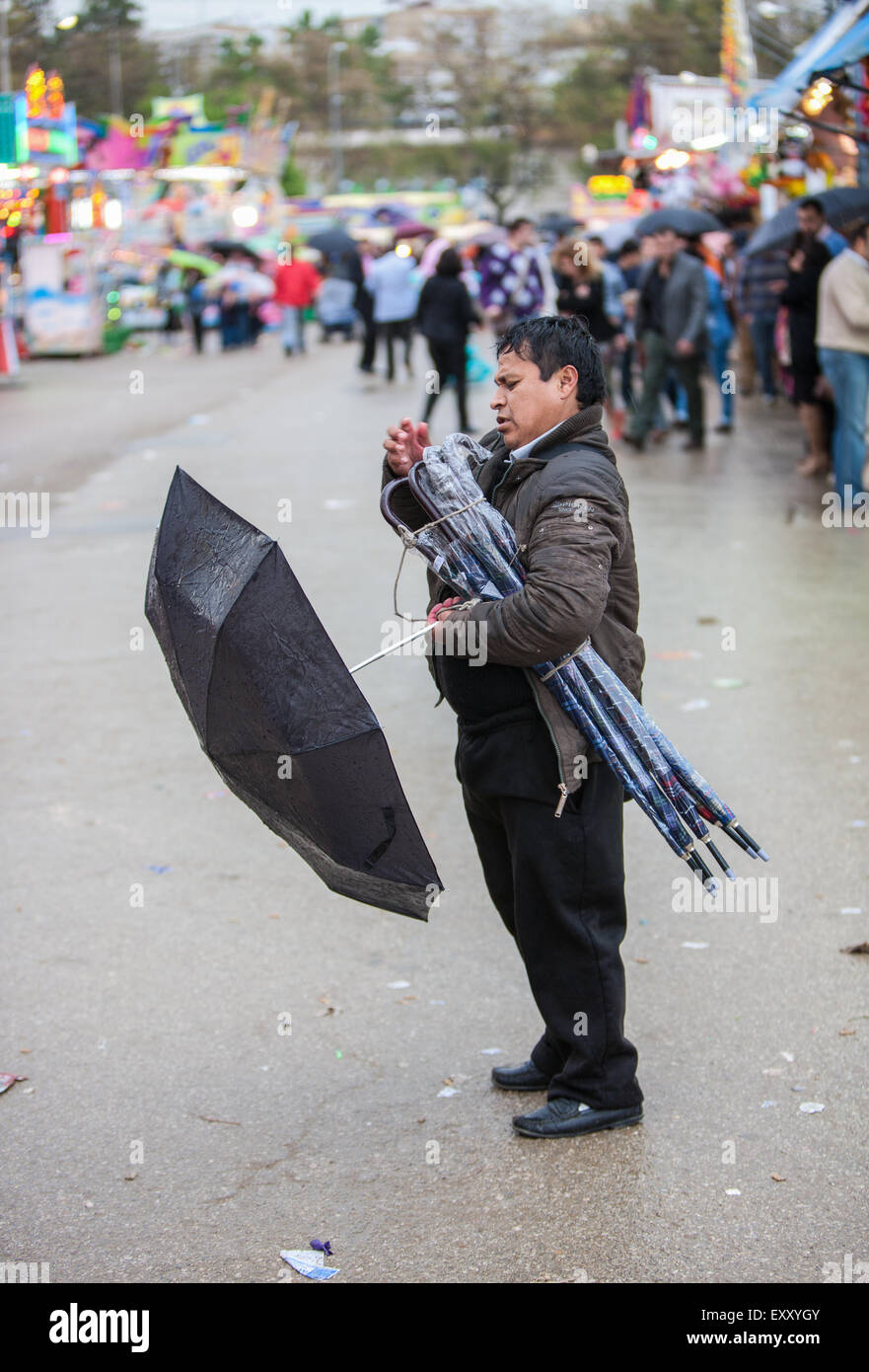 Umbrella salesman on a wet rainy day in Seville, Andalucia, Spain, Europe. At April Feria Festival. Stock Photo