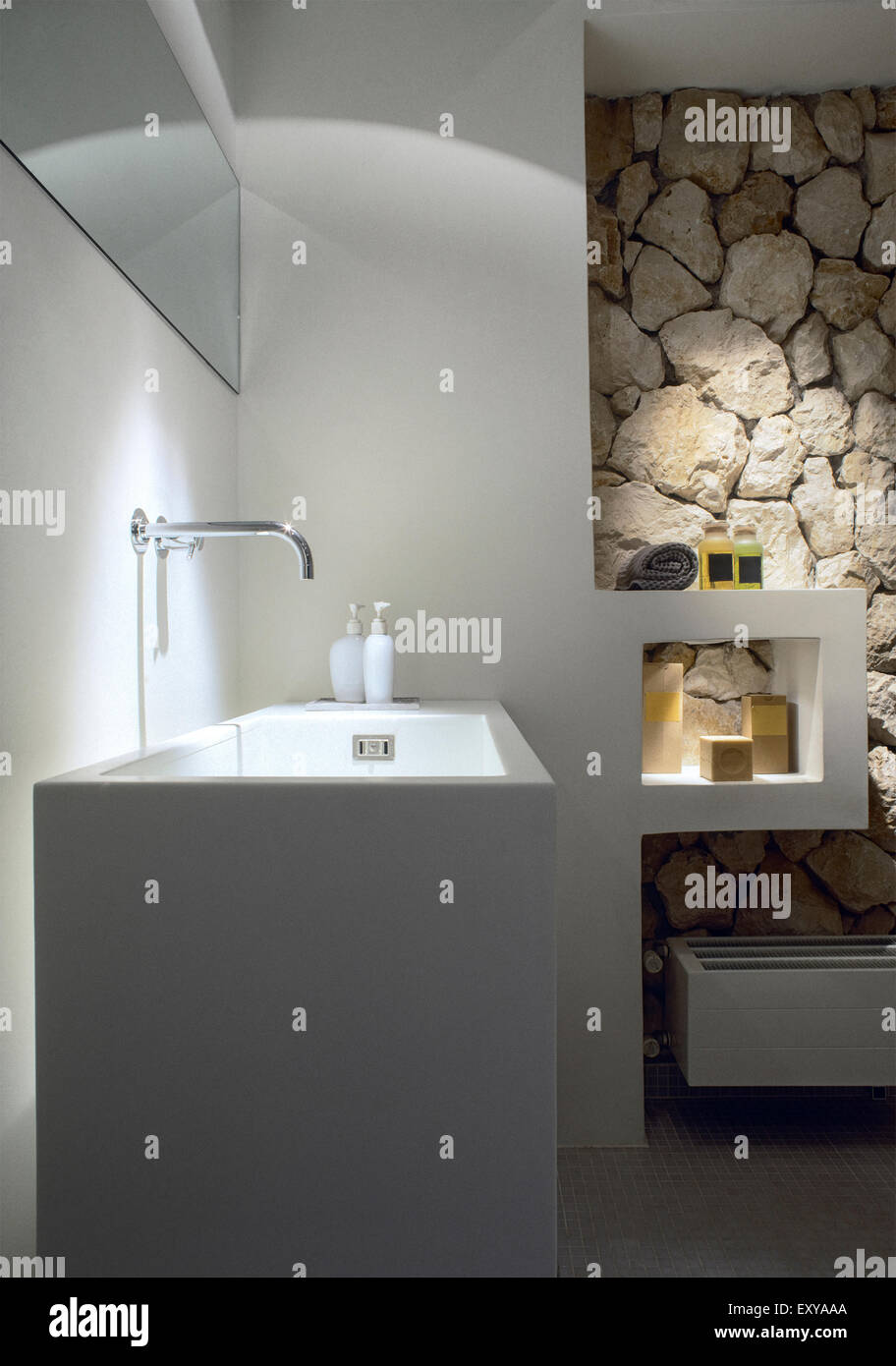 foreground of washbasin in the modern bathroom whose wall is coated with stone Stock Photo