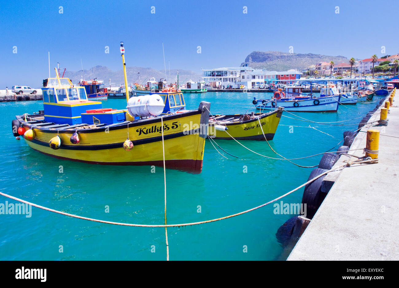 Fishing boats in Kalk Bay harbor under a clear blue sky Stock Photo