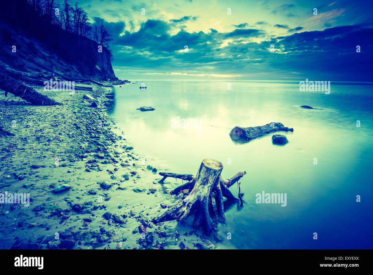 Vintage photo of beautiful rocky sea shore at sunrise or sunset. Long ...