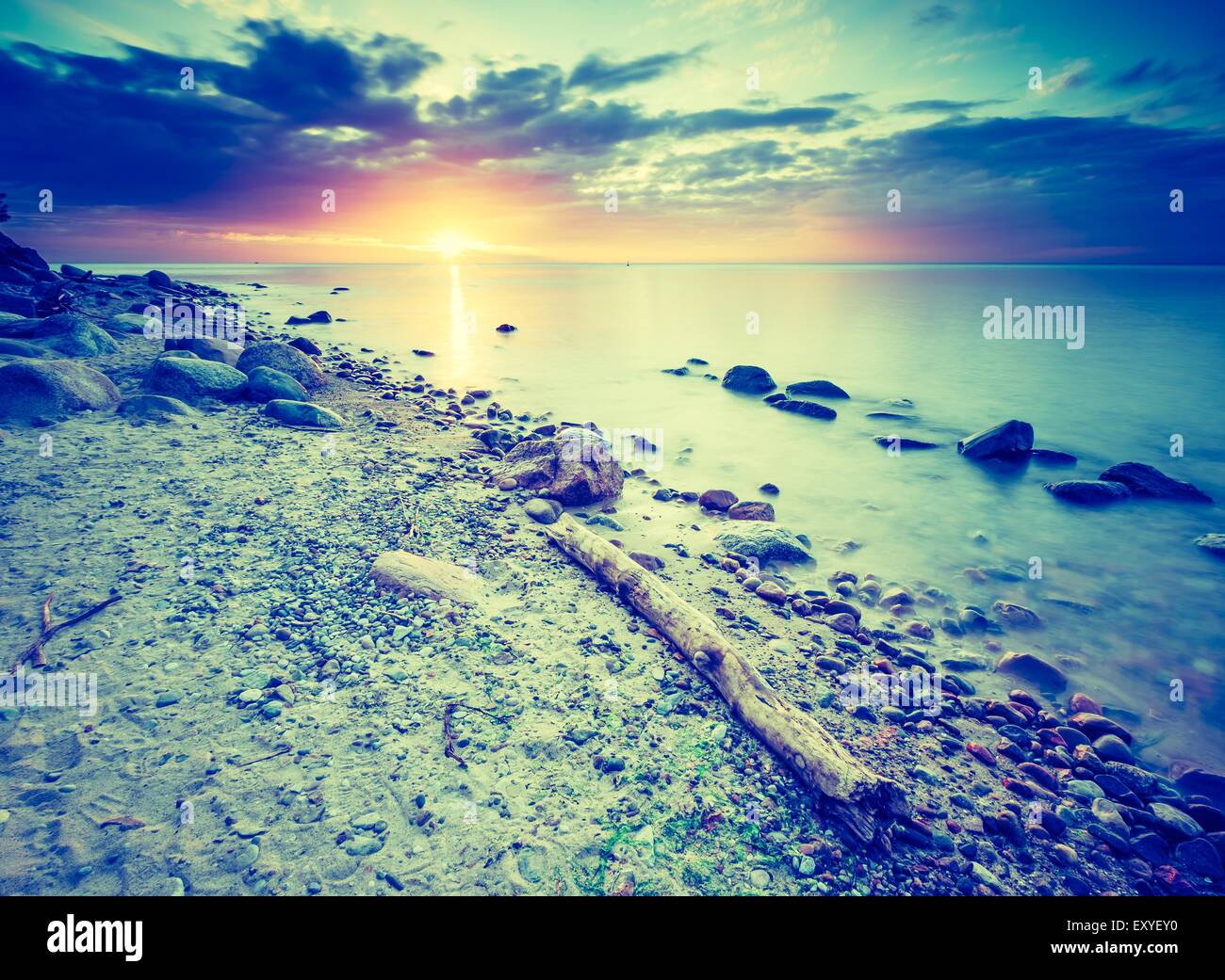 Vintage photo of beautiful rocky sea shore at sunrise or sunset. Long ...