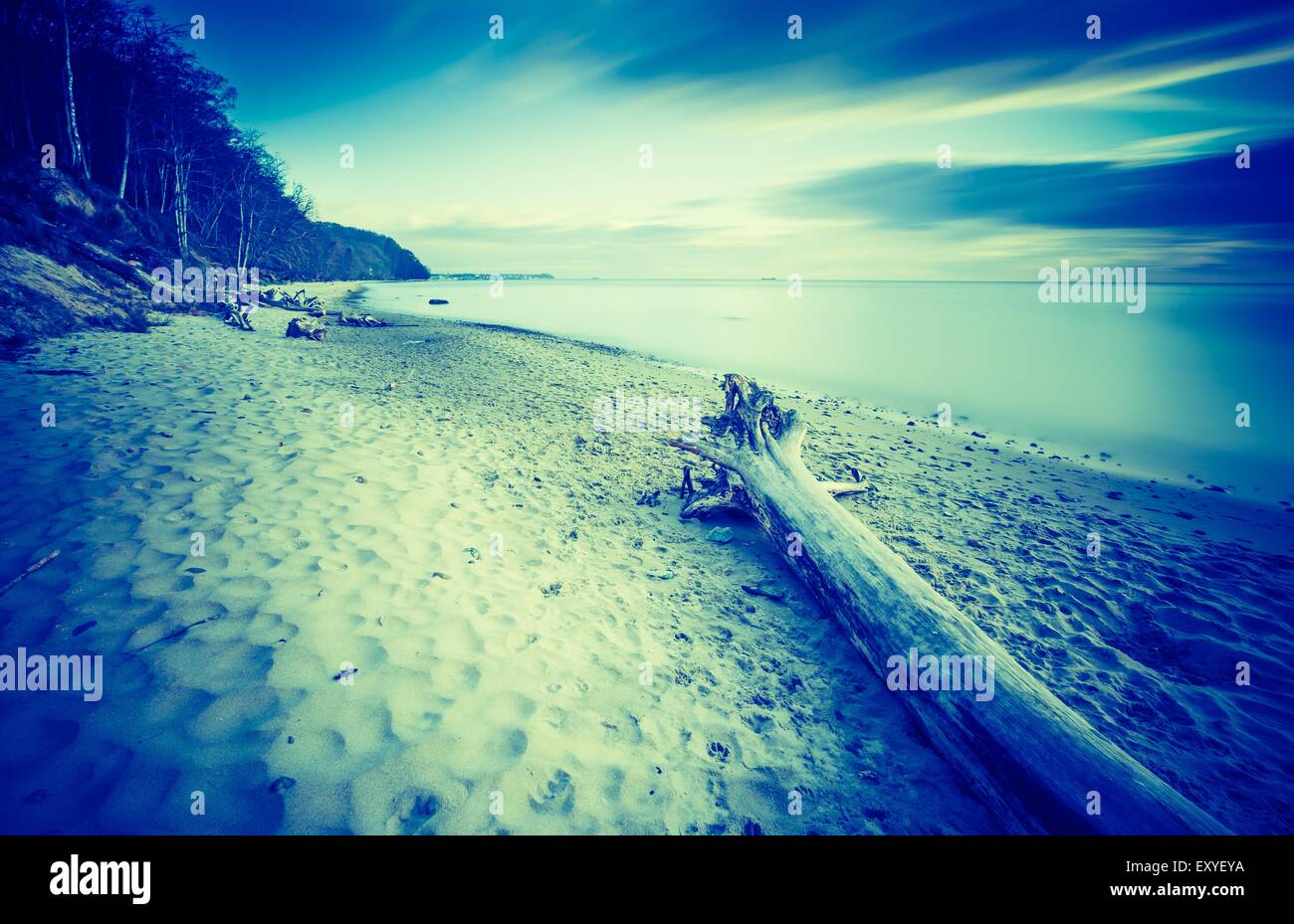 Vintage photo of beautiful rocky sea shore at sunrise or sunset. Long ...