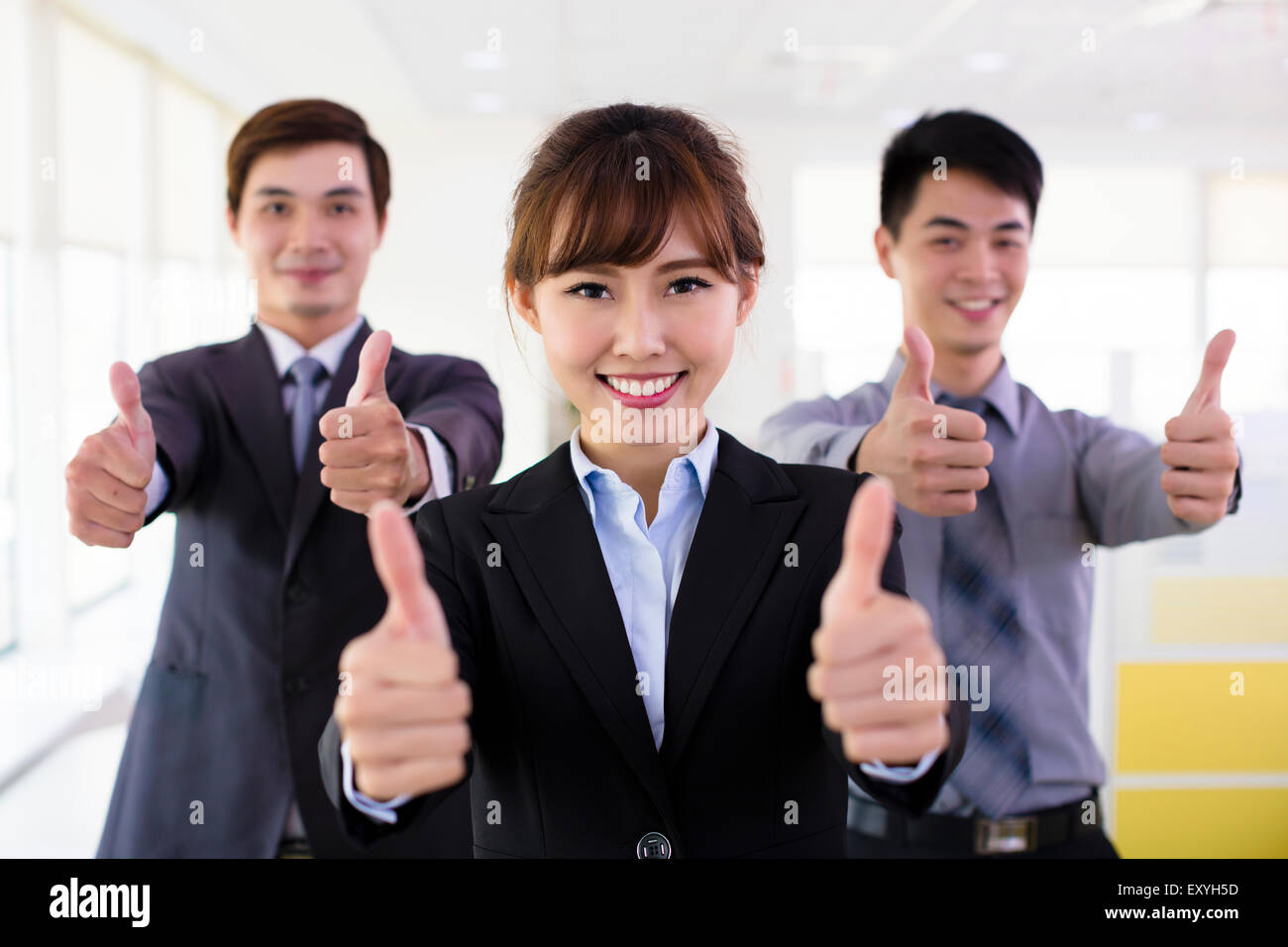 Successful business people with thumbs up Stock Photo - Alamy