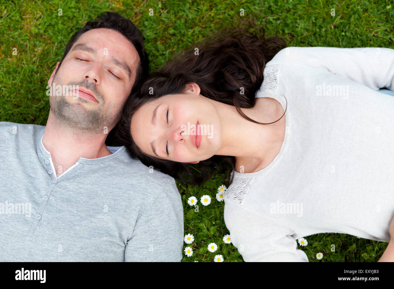 View of an Attractive couple lying in grass at the park Stock Photo - Alamy