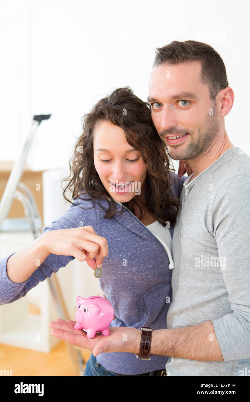 View of a Young couple saving money in a piggy bank Stock Photo - Alamy