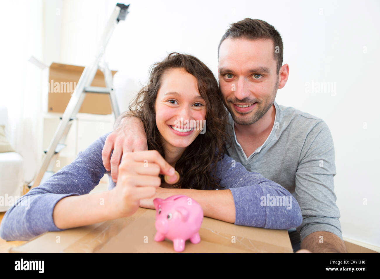 View of a Young couple saving money in a piggy bank Stock Photo - Alamy