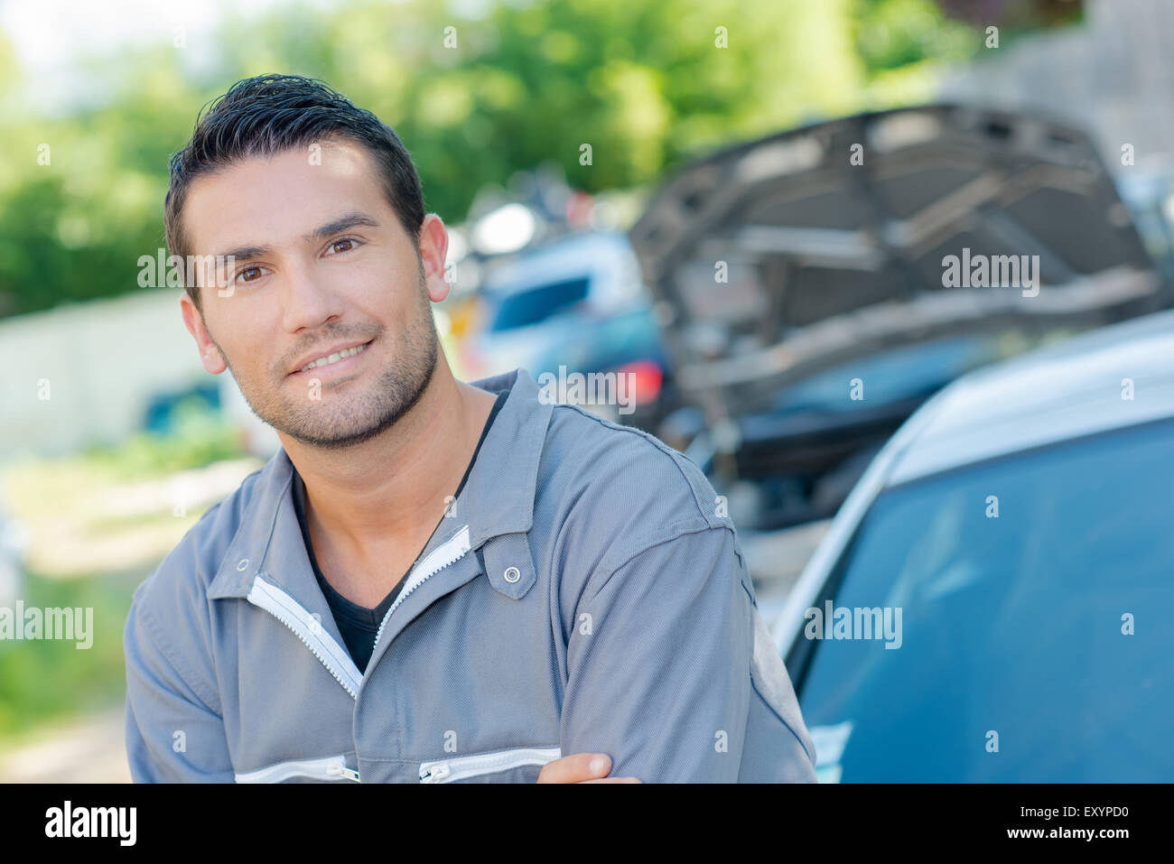 Mechanic wearing overalls stood by a car Stock Photo Alamy