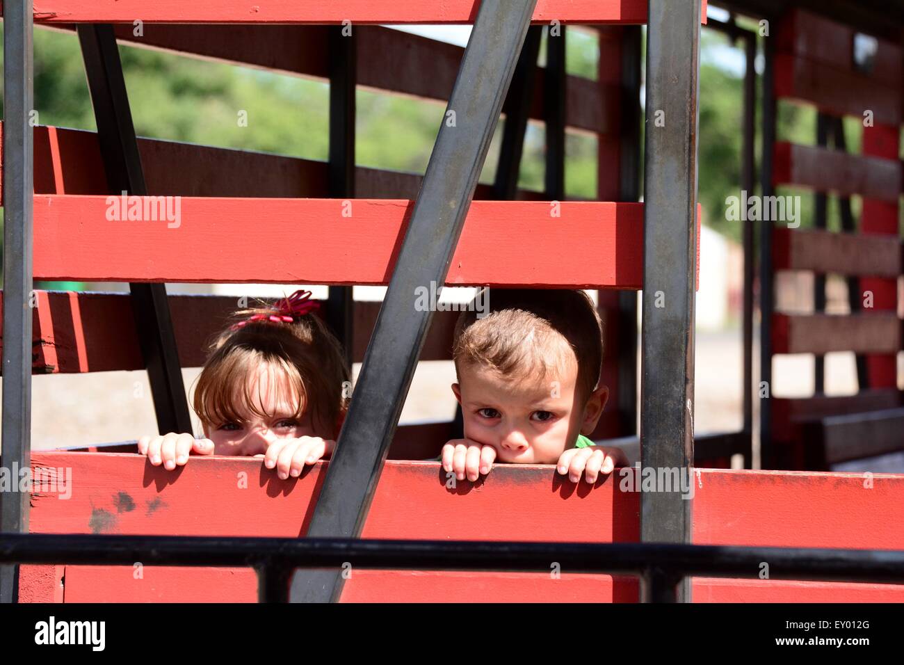 Two children peeking between the slats of a train car Albuquerque, New Mexico - USA Stock Photo