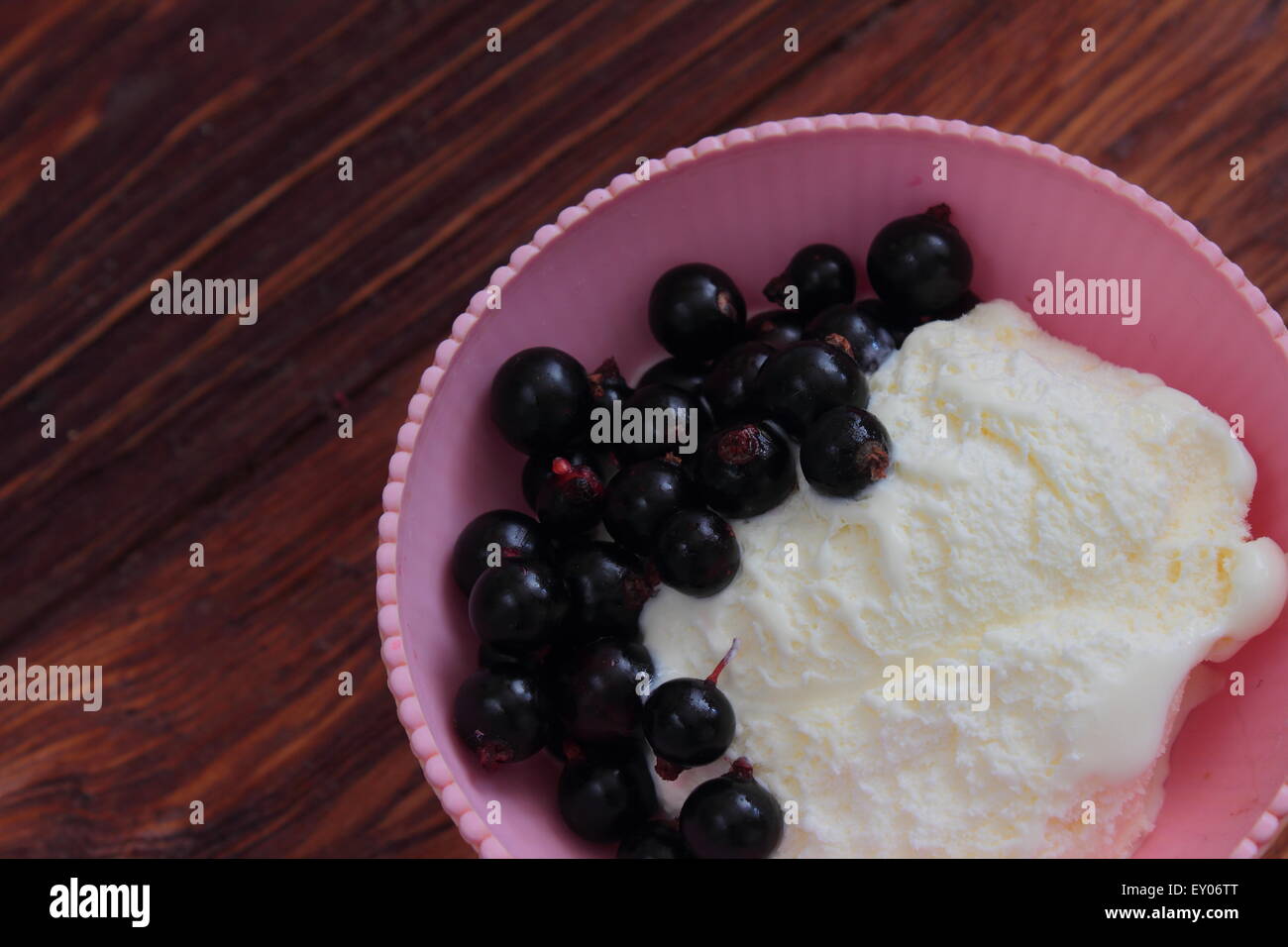 on a wooden board sweet dessert of ice cream with black currant Stock Photo