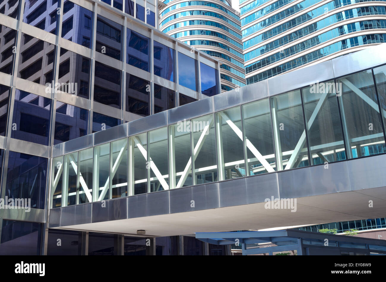 modern architecture of glass skyscrapers and reflections in windows with skyway over street Stock Photo