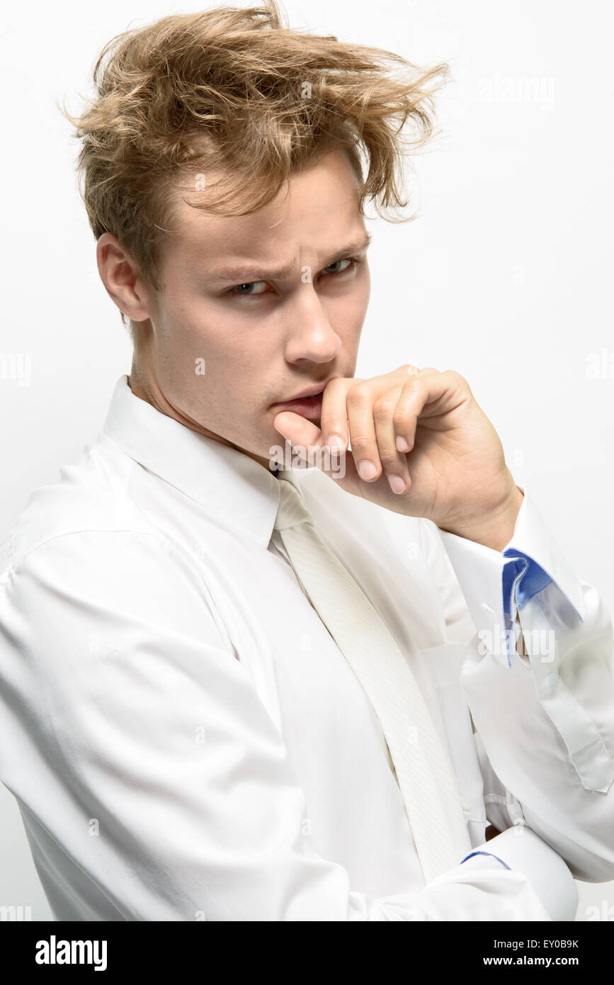 A handsome young man, male model, wearing a white shirt with white necktie, messy hair looking sick Stock Photo