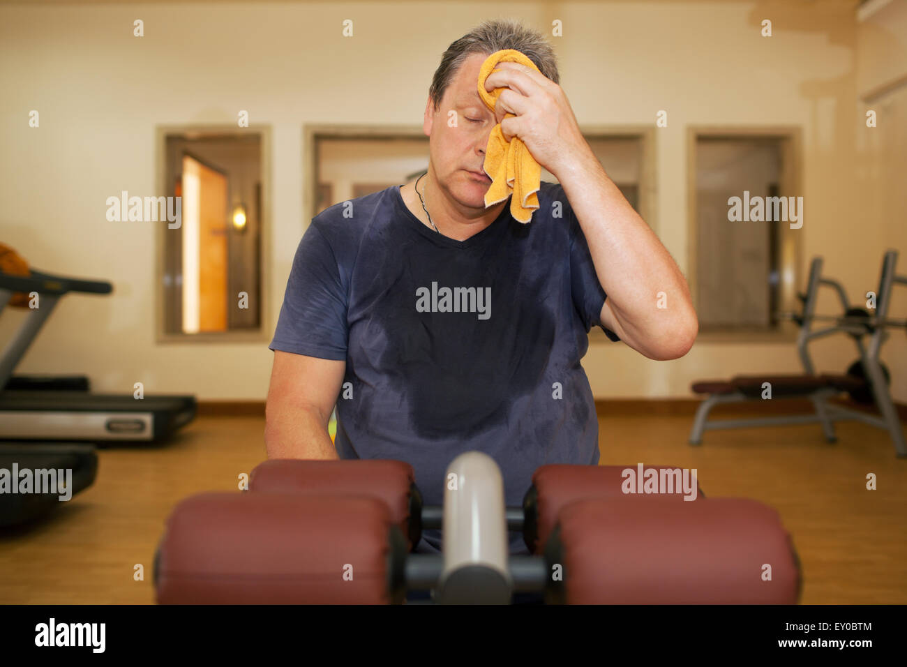 Tired man wiping sweat after workout Stock Photo