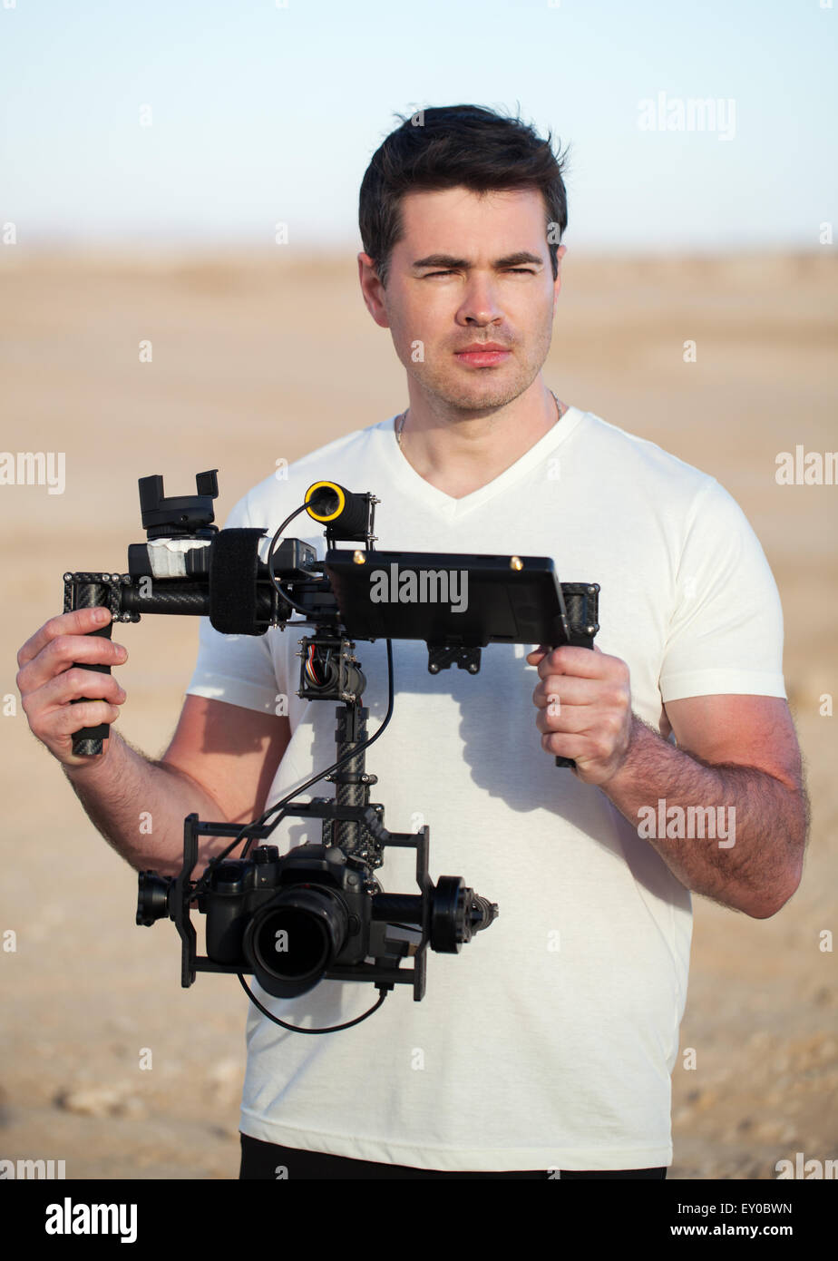 Videographer with steadicam equipment on the beach Stock Photo