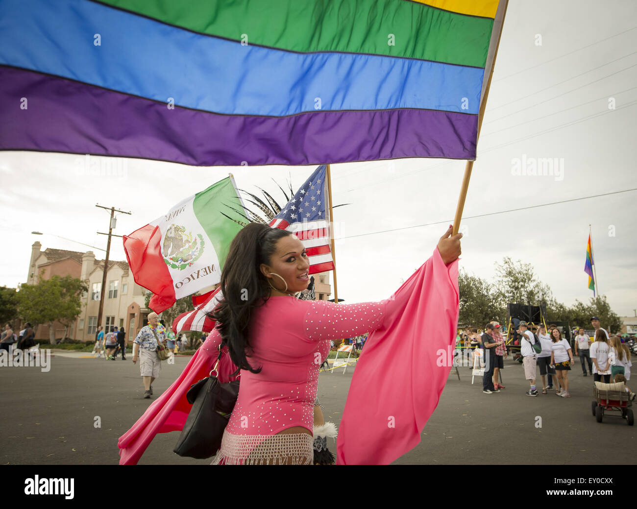 San Diego, California, USA. 18th July, 2015. July 18, 2015 - San Diego, CA, U.S. - | Parade participants carry Mexico, U.S. and Pride flags as they make their way to the parade. Rain dampened the San Diego LGBT Pride Parade Saturday, if not the spirit of the participants. | San Diego Union-Tribune photo by David Poller © David Poller/ZUMA Wire/Alamy Live News Stock Photo