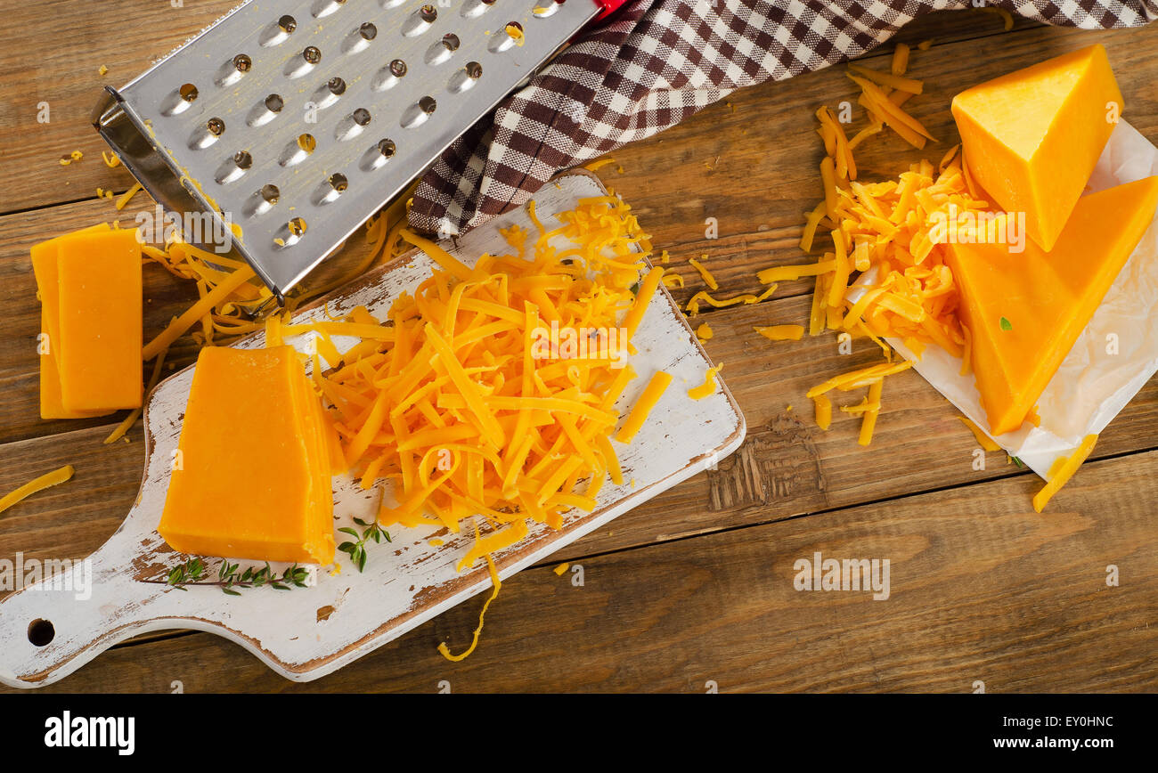 Cheddar Cheese on white cutting Board. Top view Stock Photo