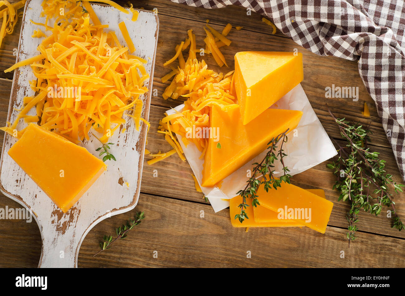 Cheddar Cheese on  a white wooden cutting Board. Top view Stock Photo