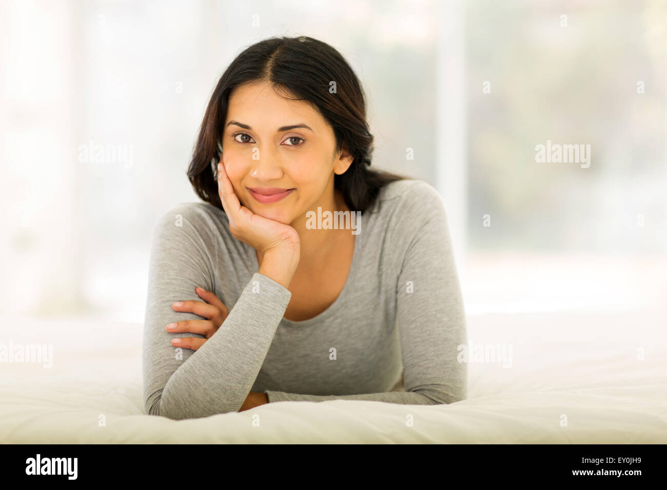 beautiful Indian woman relaxing on the bed Stock Photo