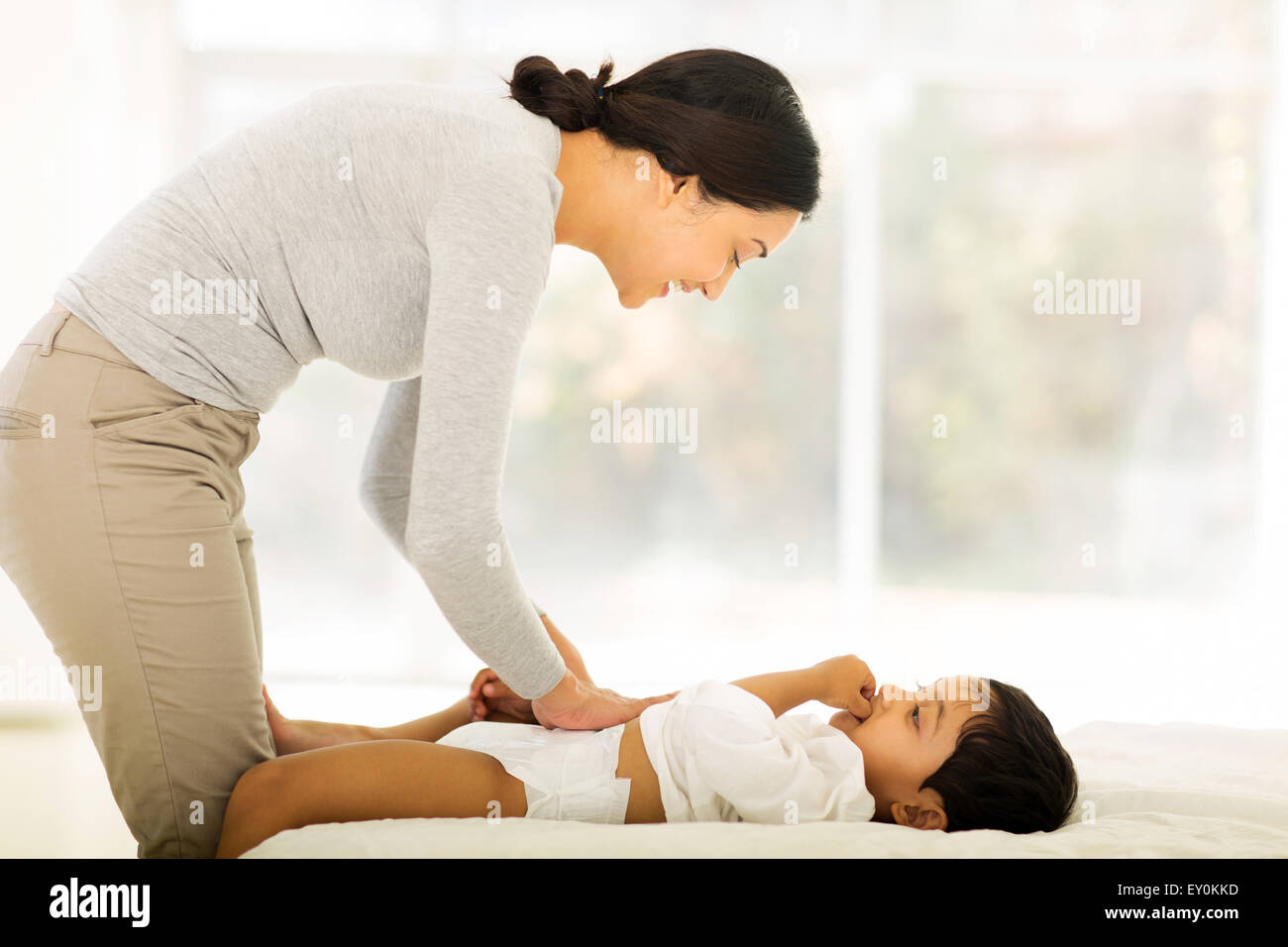 happy Indian mother changing baby nappy Stock Photo