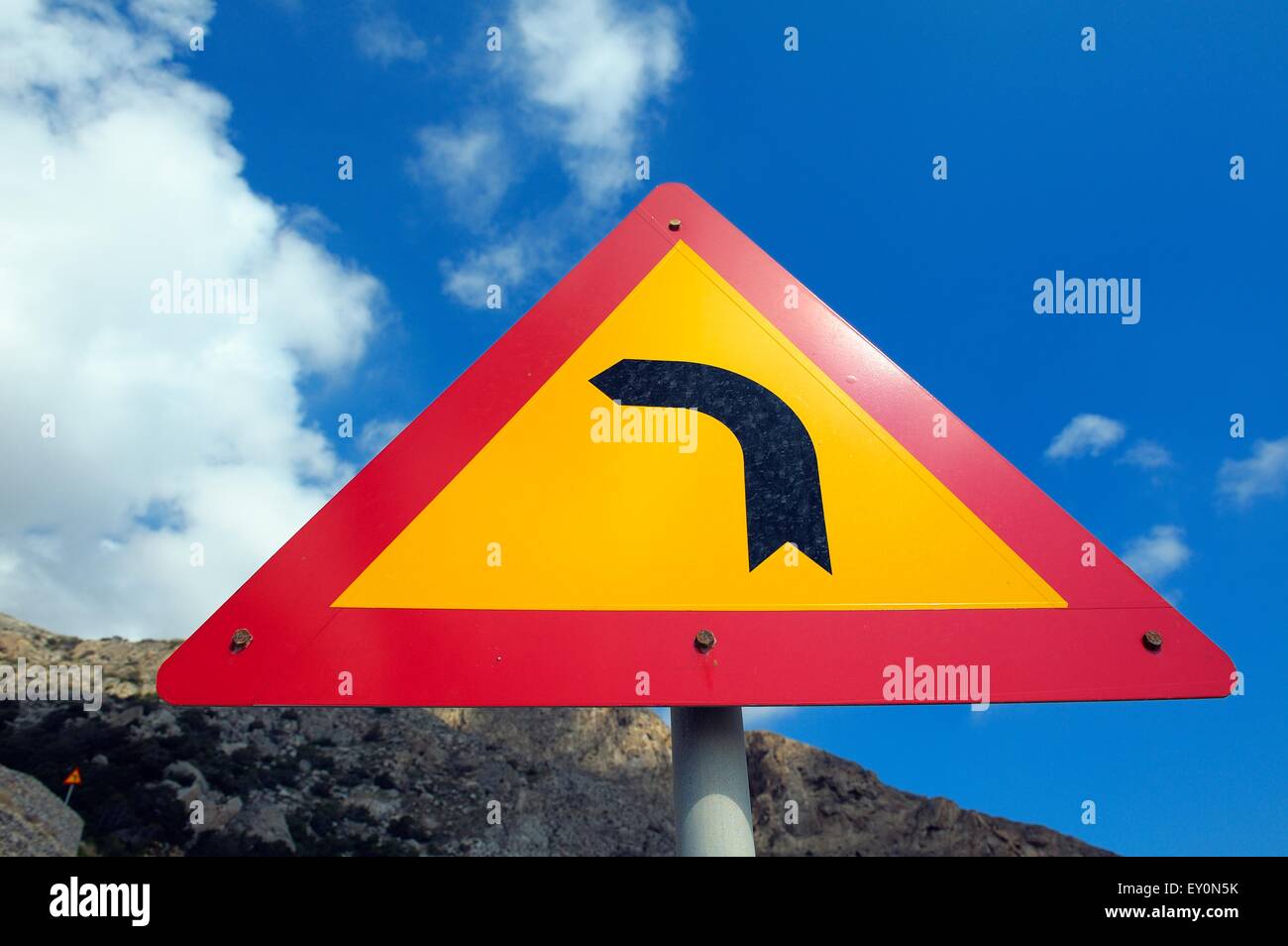 A road sign indicating left turning bend ahead Stock Photo