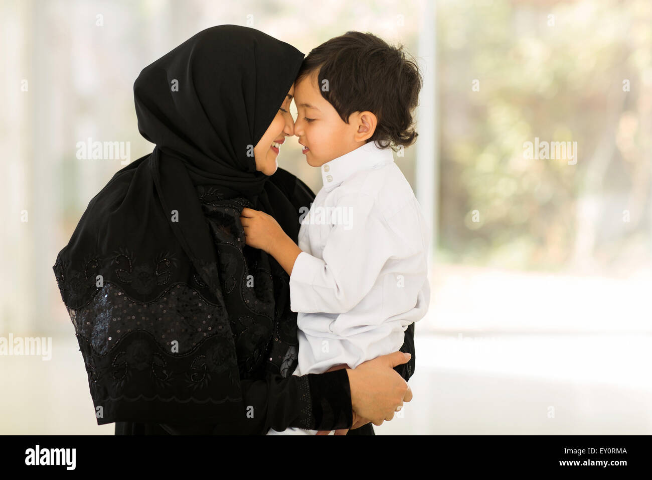 adorable middle eastern woman playing with her son at home Stock Photo
