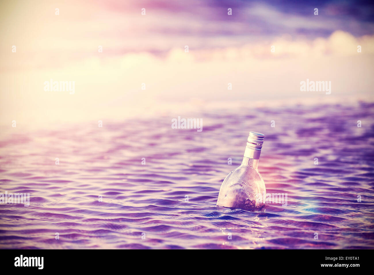 Vintage toned bottle of vodka in water, alcohol problem concept Stock