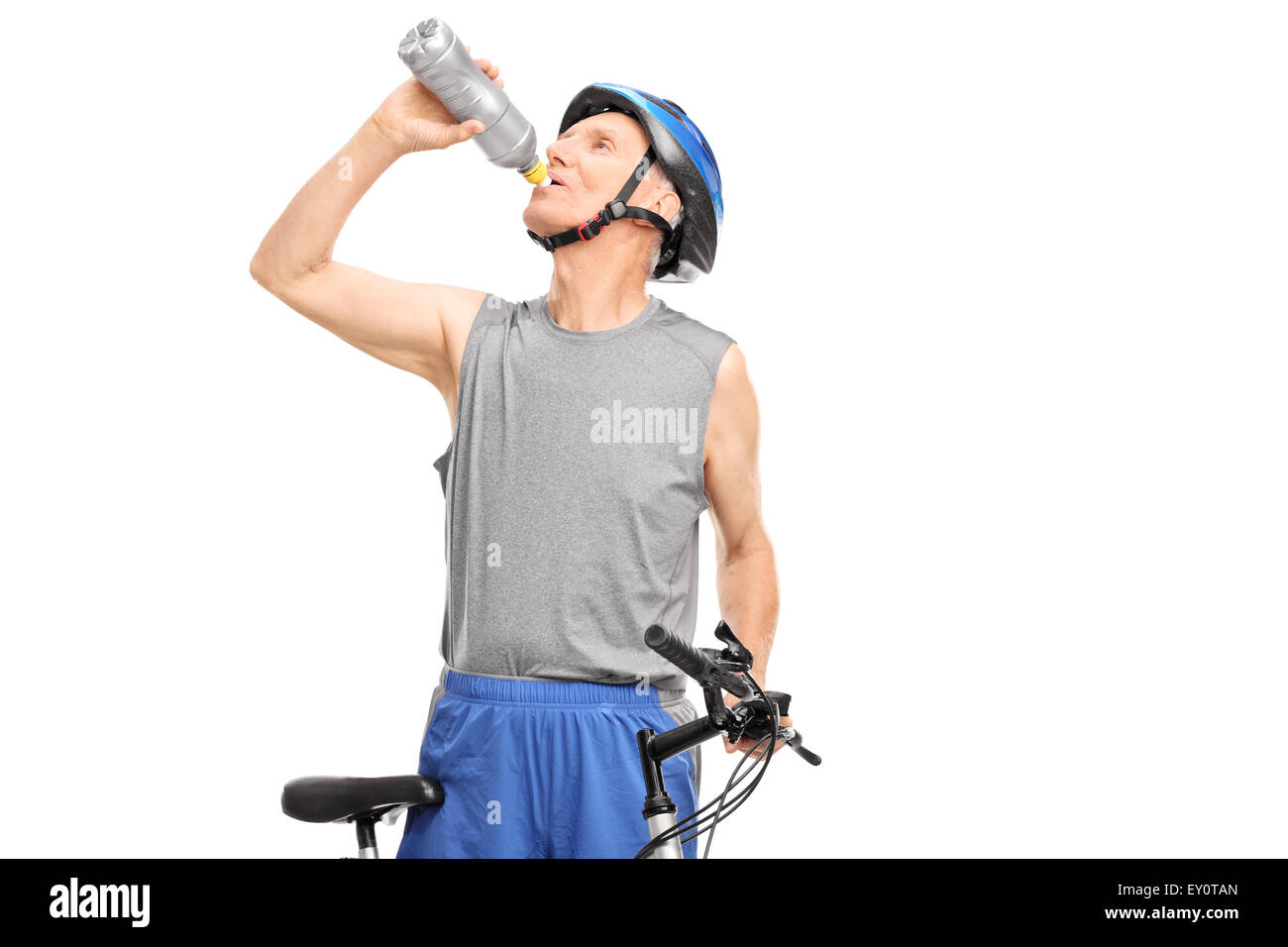 Senior biker standing behind his bicycle and drinking water isolated on white background Stock Photo