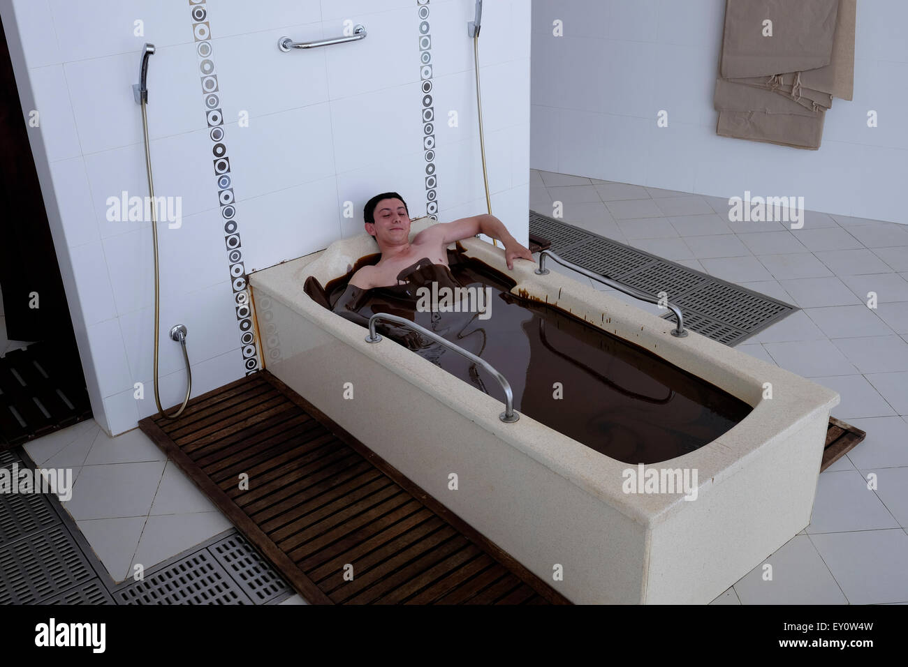 A man taking a ten minute crude oil bath offered as physical therapy