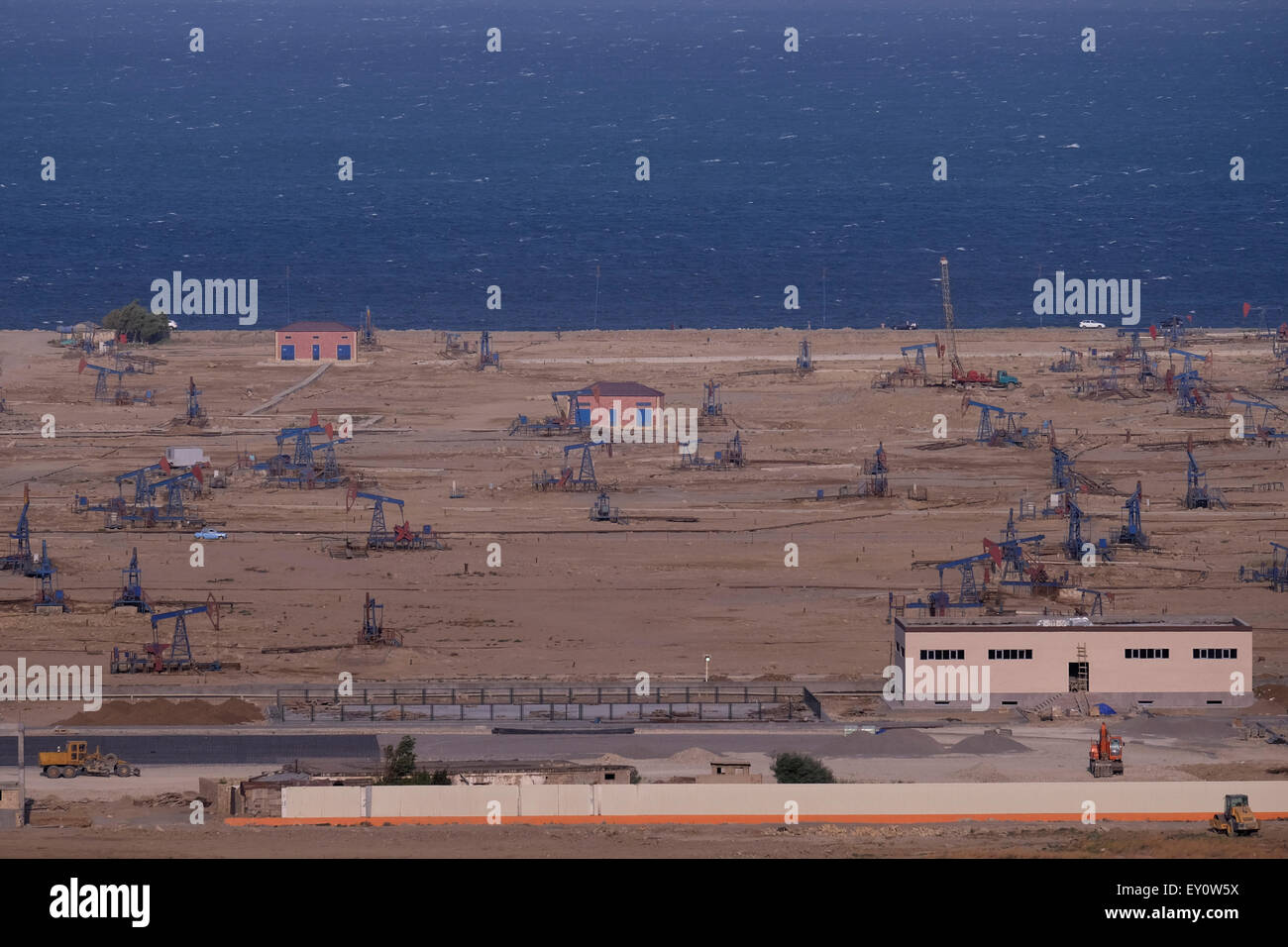 Pump jacks in oil wells at the shore of the Caspian sea at the suburbs of the city of Baku capital of Azerbaijan Stock Photo