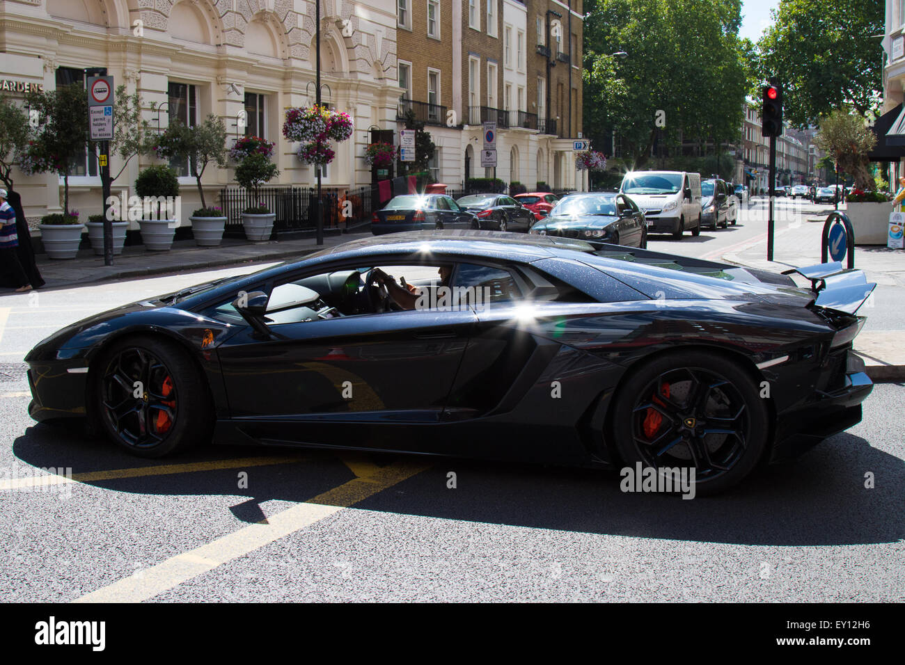 Edgeware Road, London, UK. 19th July, 2015. The driver of a 750 hp Lamborghini engages in a text conversation whilst in charge of his 217mph hypercar in London's Edgeware Road, seemingly unaware of the dangers of not properly concentrating whilst in chage of such an immesely pwerful vehicle in such a busy area. Credit:  Paul Davey/Alamy Live News Stock Photo