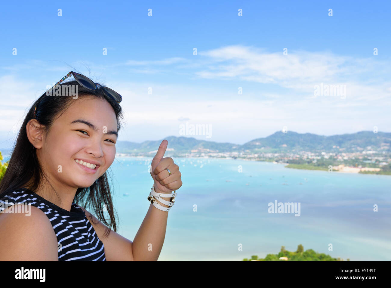 Women tourist smiling happy along with thumb raised expresses admiration for beautiful landscape of the sea and island on Khao-K Stock Photo
