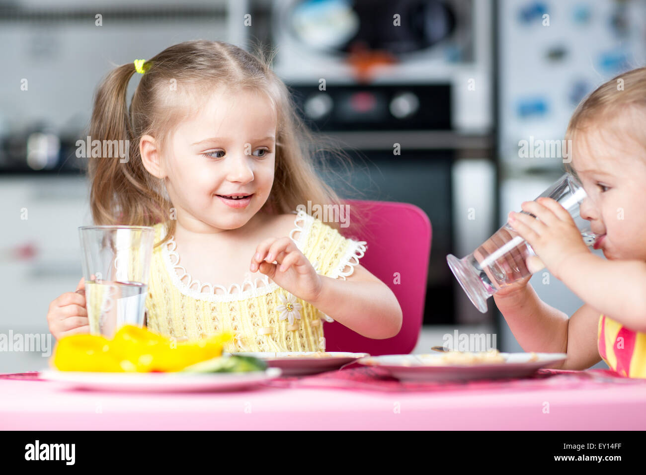 Cute little children drinking water at daycare Stock Photo