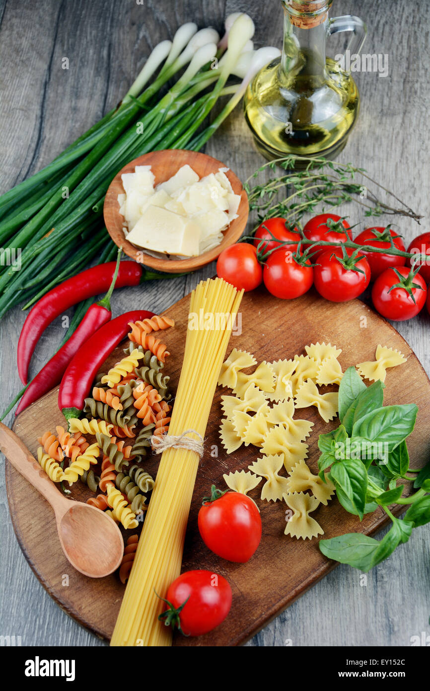 Different kinds of raw pasta on the wooden table Stock Photo