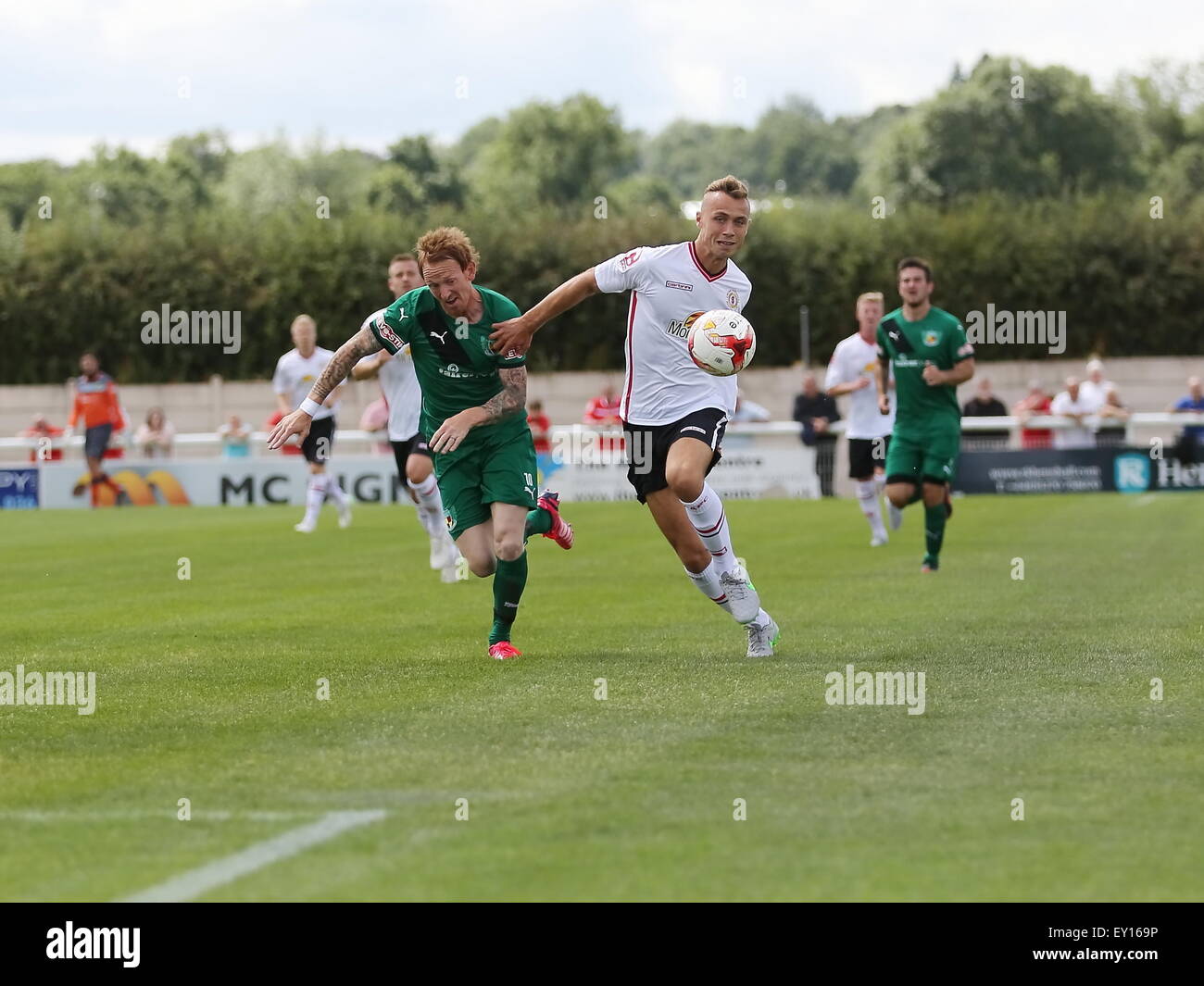 Nantwich, UK. 19th July, 2015. Nantwich Town's Steve Jones powers forward with Crewe Alexandra's George Ray defending during the pre-season friendly match at The Weaver Stadium, Nantwich as Nantwich Town entertained Crewe Alexandra. Credit:  SJN/Alamy Live News Stock Photo