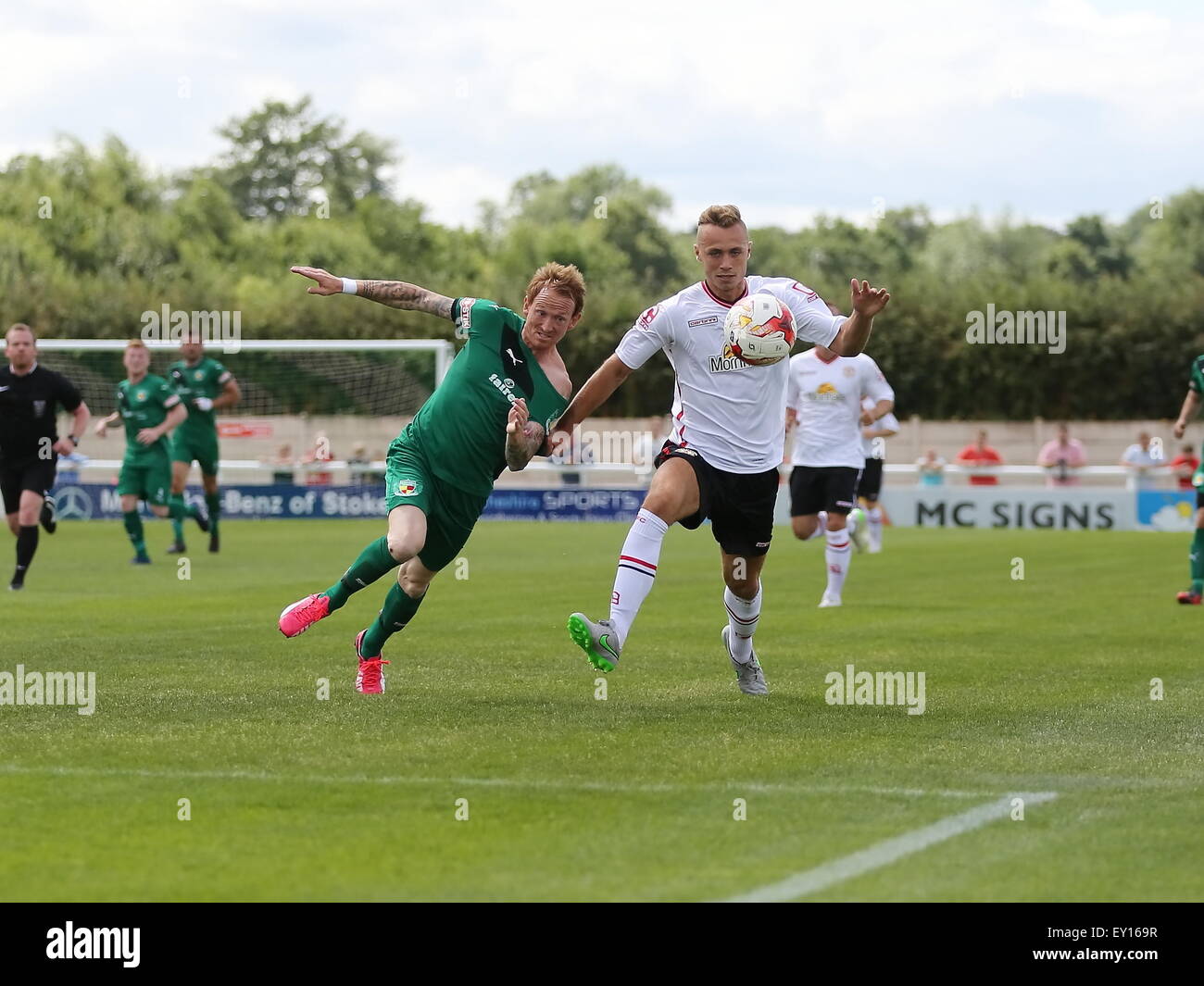 Nantwich, UK. 19th July, 2015. Nantwich Town's Steve Jones powers forward with Crewe Alexandra's George Ray defending during the pre-season friendly match at The Weaver Stadium, Nantwich as Nantwich Town entertained Crewe Alexandra. Credit:  SJN/Alamy Live News Stock Photo