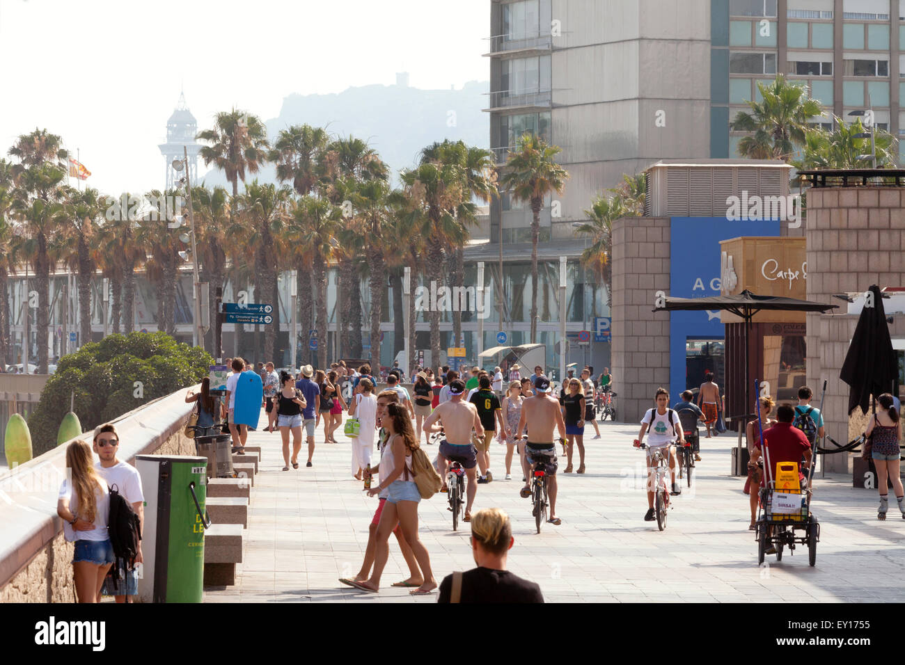 Tourists mix with local people on the Passeig Maritim, ( Esplanade ) joining Port Olimpic to Barceloneta, Barcelona, Spain Stock Photo