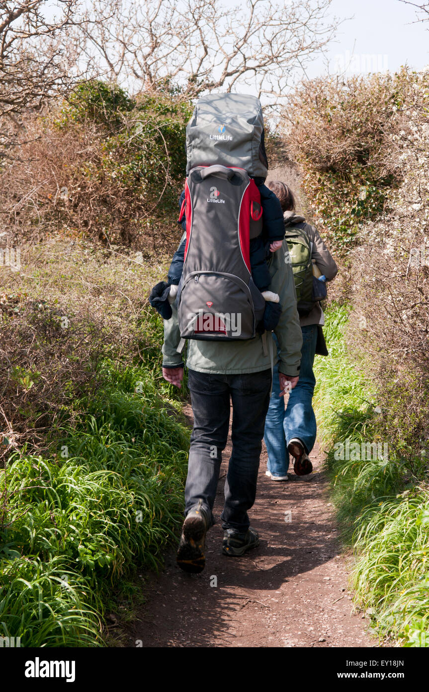 Couple out for a walk with their baby asleep in a baby carrier Stock Photo