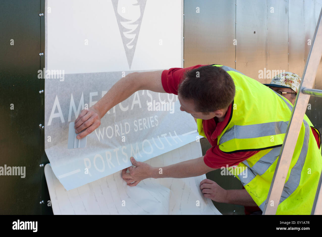 workers putting up posters for the americas cup in southsea hampshire england uk 2015 Stock Photo
