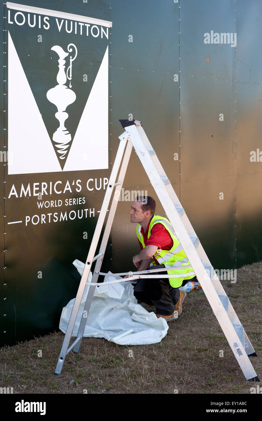 worker putting up posters for the americas cup in southsea hampshire england uk 2015 Stock Photo