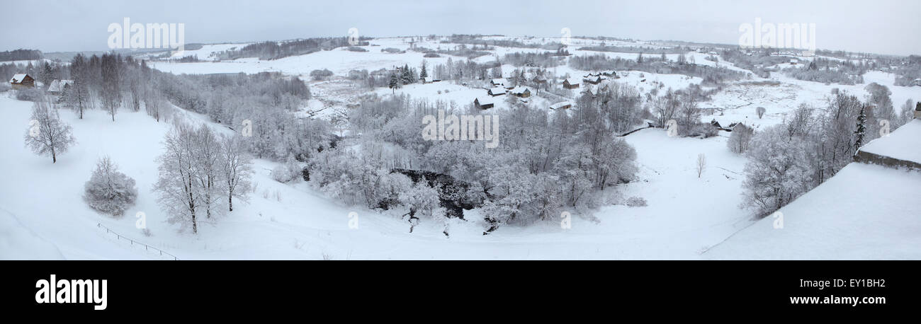Russian winter. Snow-covered landscape with the village of Kruppsk next to the Izborsk Fortress near Pskov, Russia. Panorama fro Stock Photo