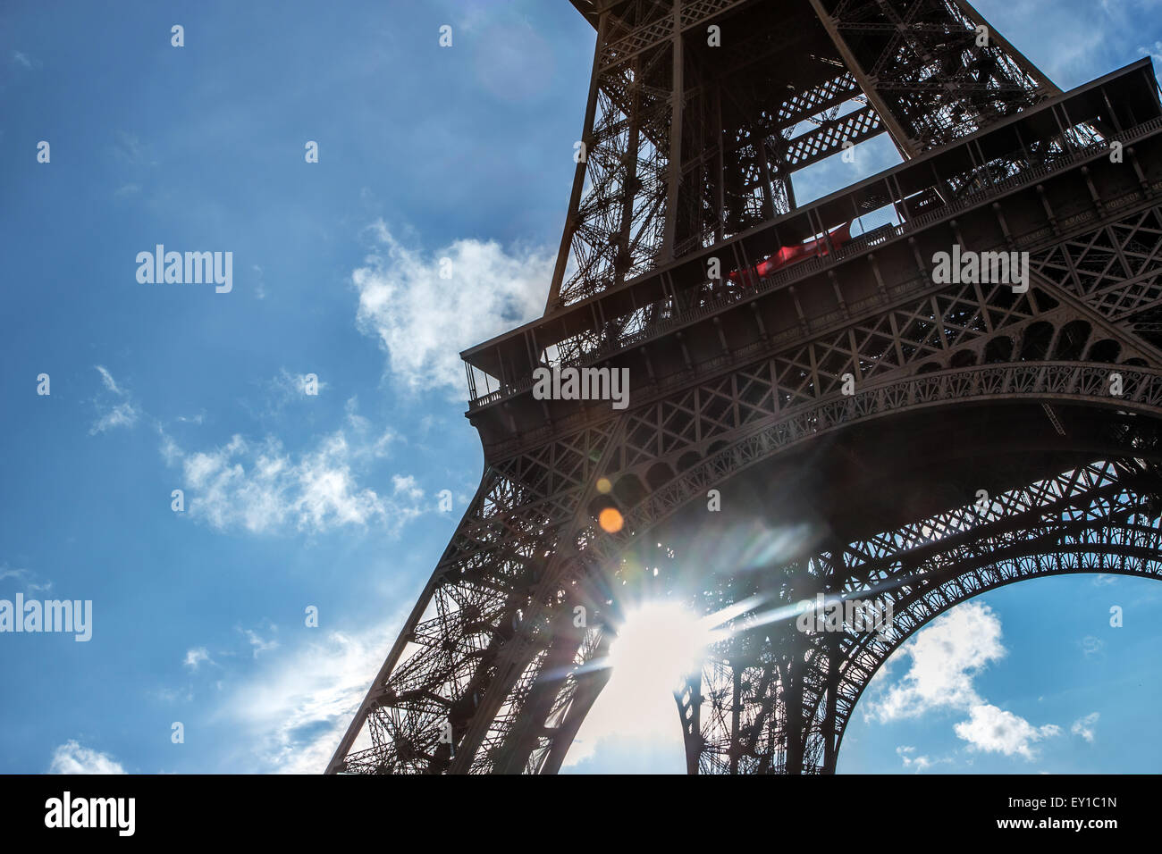 Sun shines through construction Eiffel Tower Stock Photo