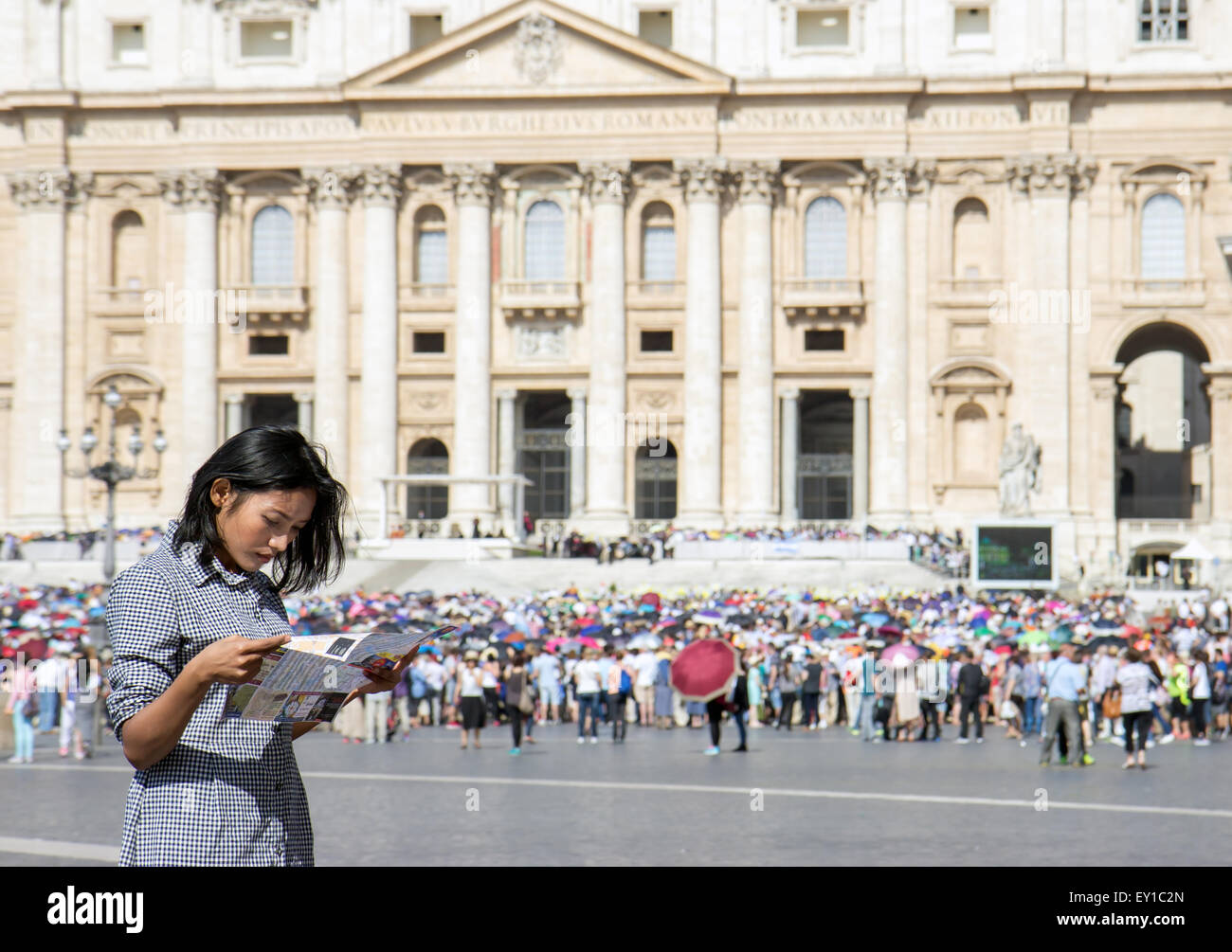 woman studying a city map at St. Peter's Basilica in Vatican Stock Photo