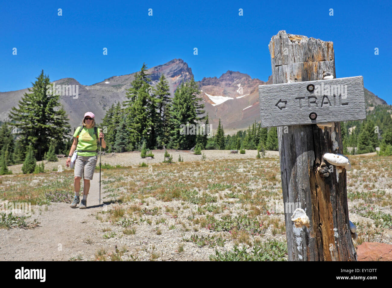 A hiker near a trail sign near Broken Top peak in the Central Oregon Cascade Mountains near Bend, Oregon Stock Photo