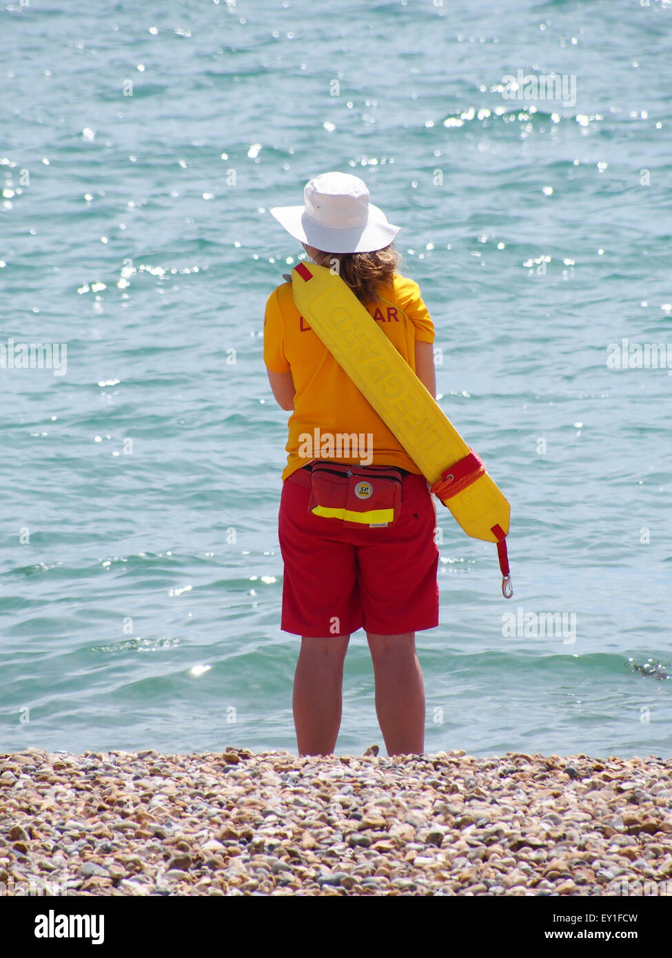 A RNLI lifeguard wearing a sun hat on Southsea beach, Portsmouth Stock Photo