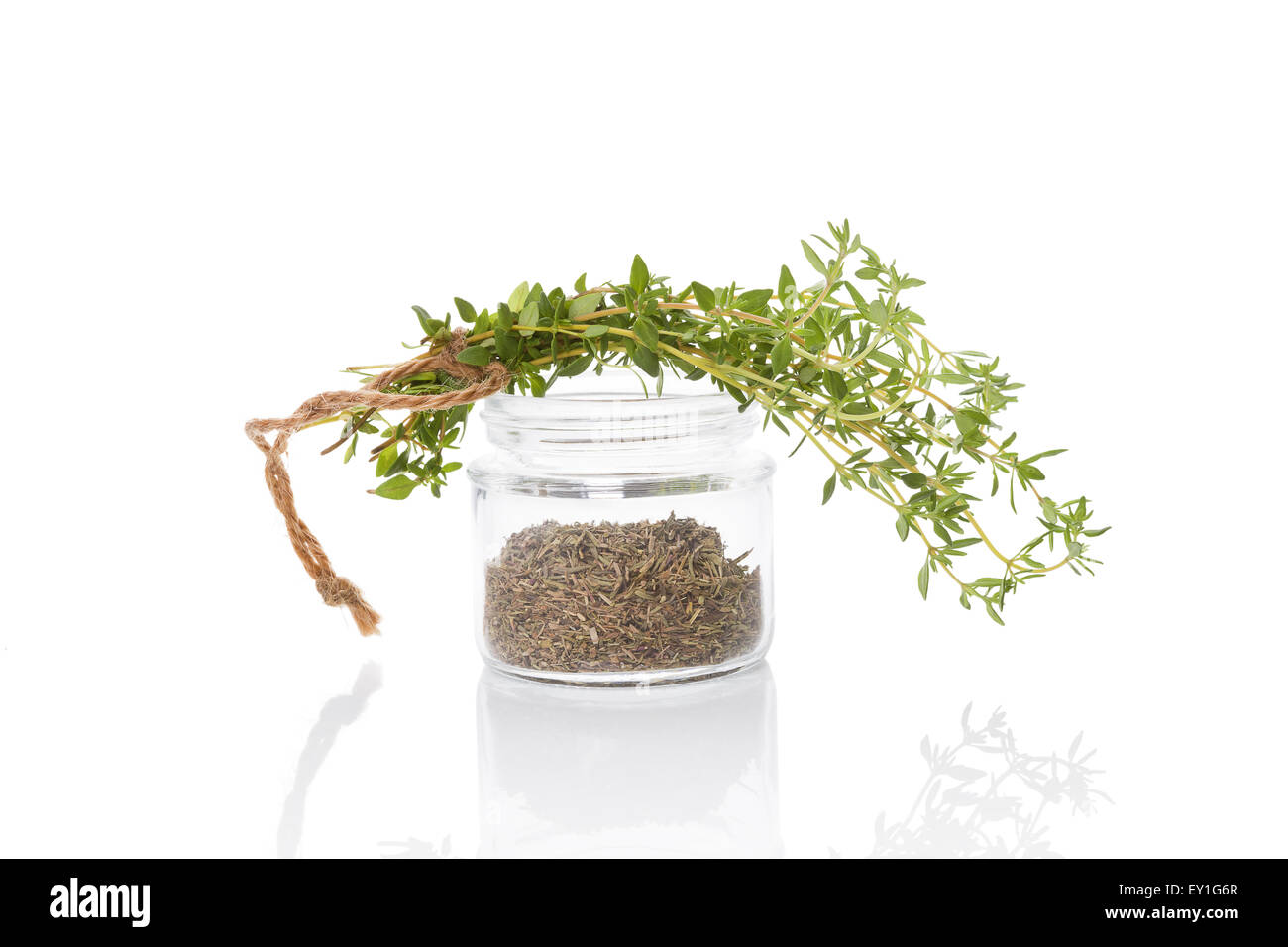 Fresh thyme and dry thyme spice in glass jar isolated on white
