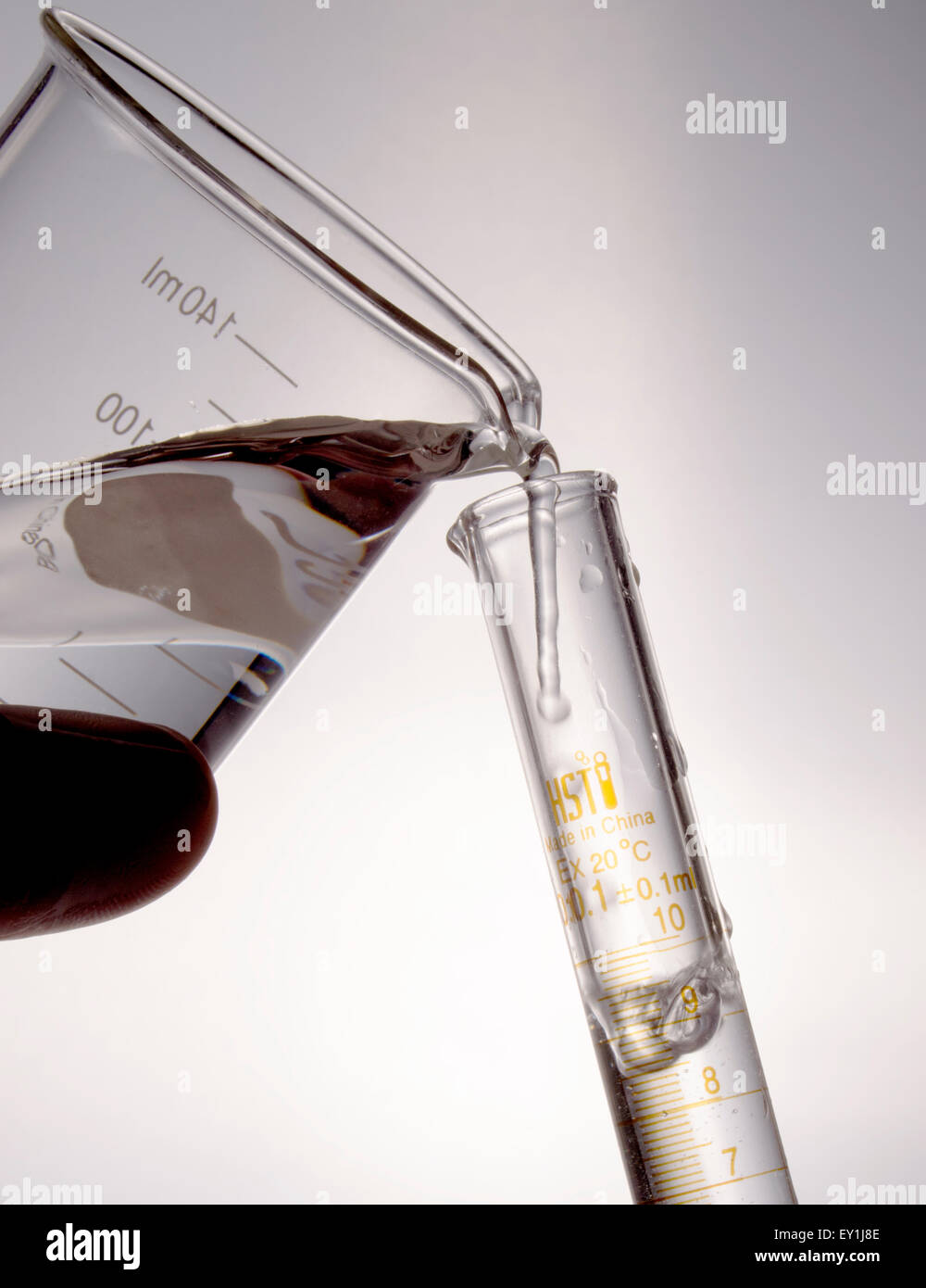 Pouring solution from beaker to test tube Stock Photo Alamy