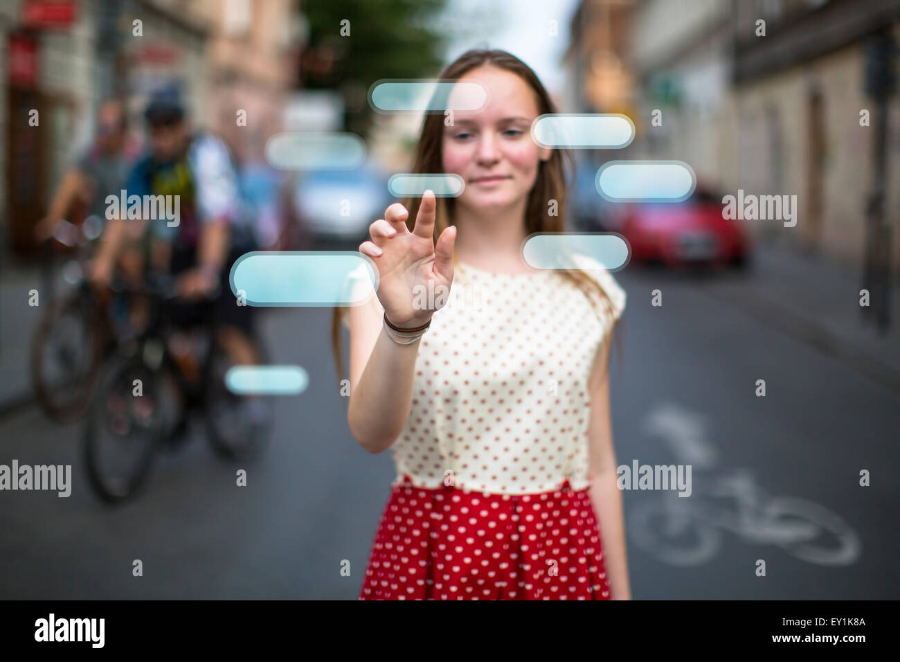 Young cute teen girl in the street presses an imaginary button in the air. Buttons with place for your text. Stock Photo