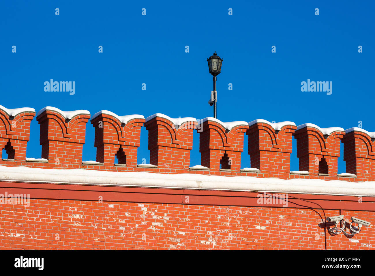 Red Kremlin wall and a lamp against the background of clear dark blue sky Stock Photo